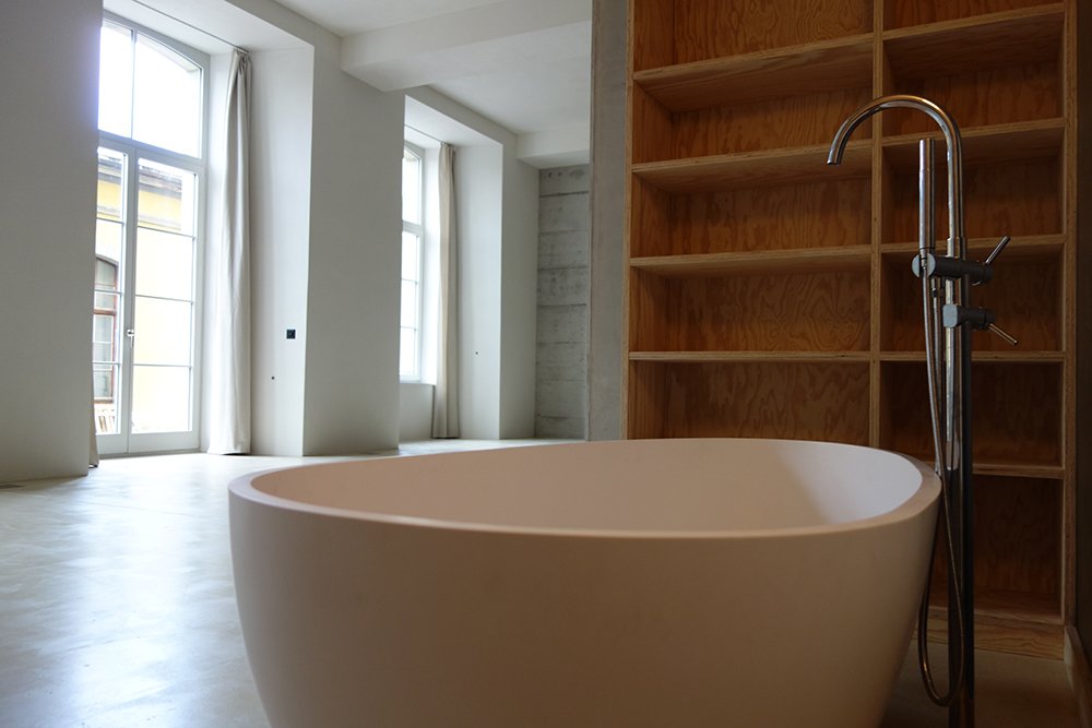 Badbereich mit freistehender Wanne und gegliederten Wandflächen