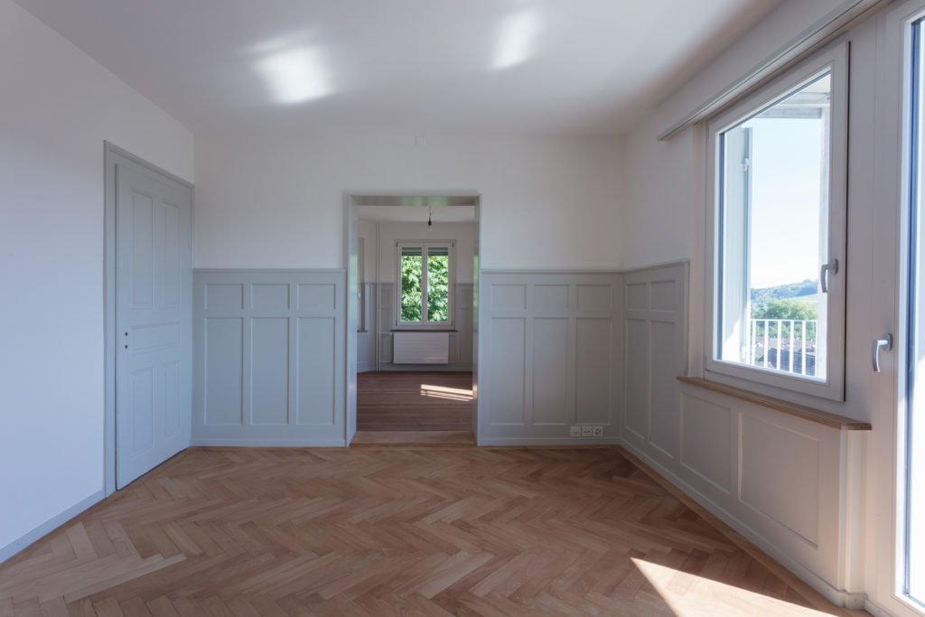 Historischer Innenraum mit gestrichenem Wandtäfer und Holzboden