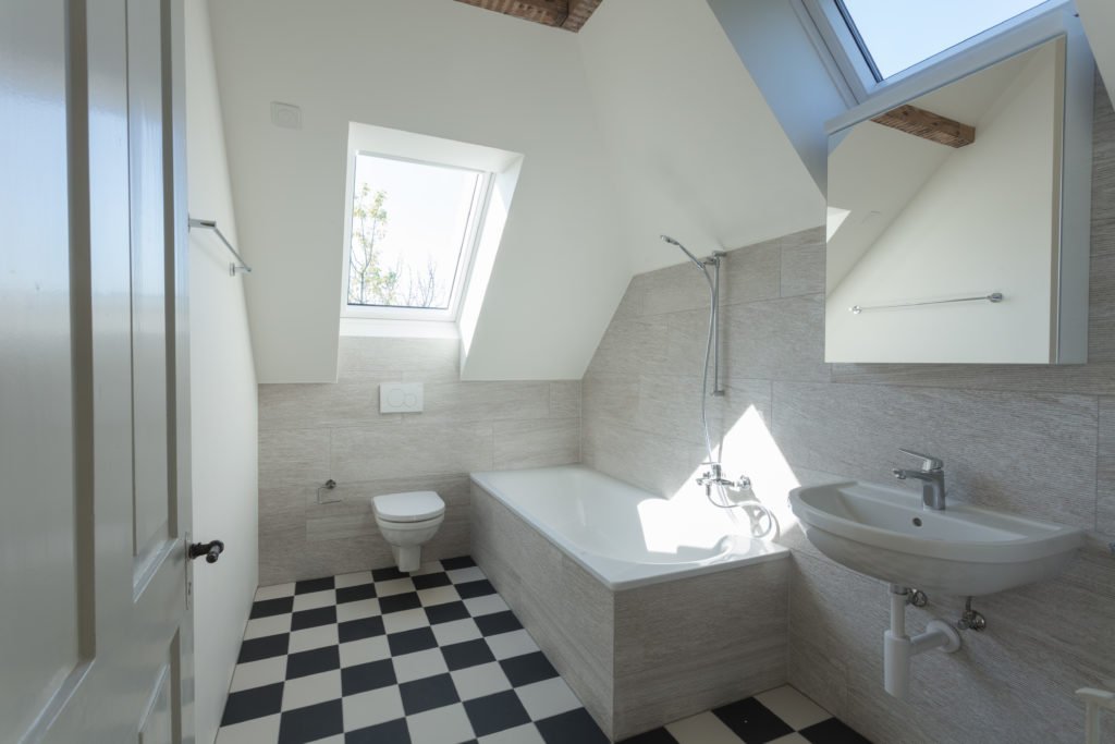 Badezimmer mit hell gestrichenen Dachschrägen