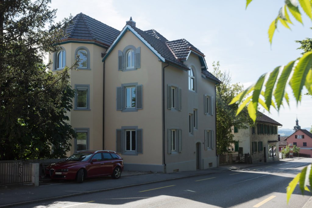 Hausfassade mit farbig abgesetzten Fenstereinfassungen