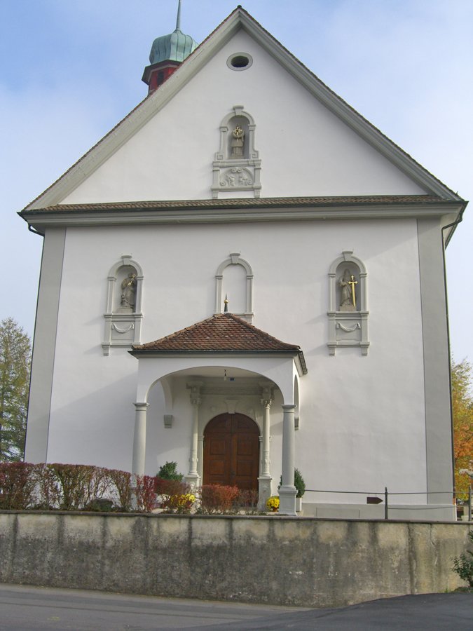 Kirchenfassade mit Figuren in Nischen und ĂĽberdachtem Eingang