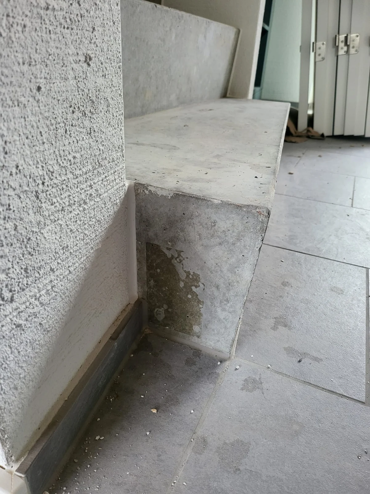 Betonbank mit sichtbaren Ausbesserungsstellen an der Stirnfläche