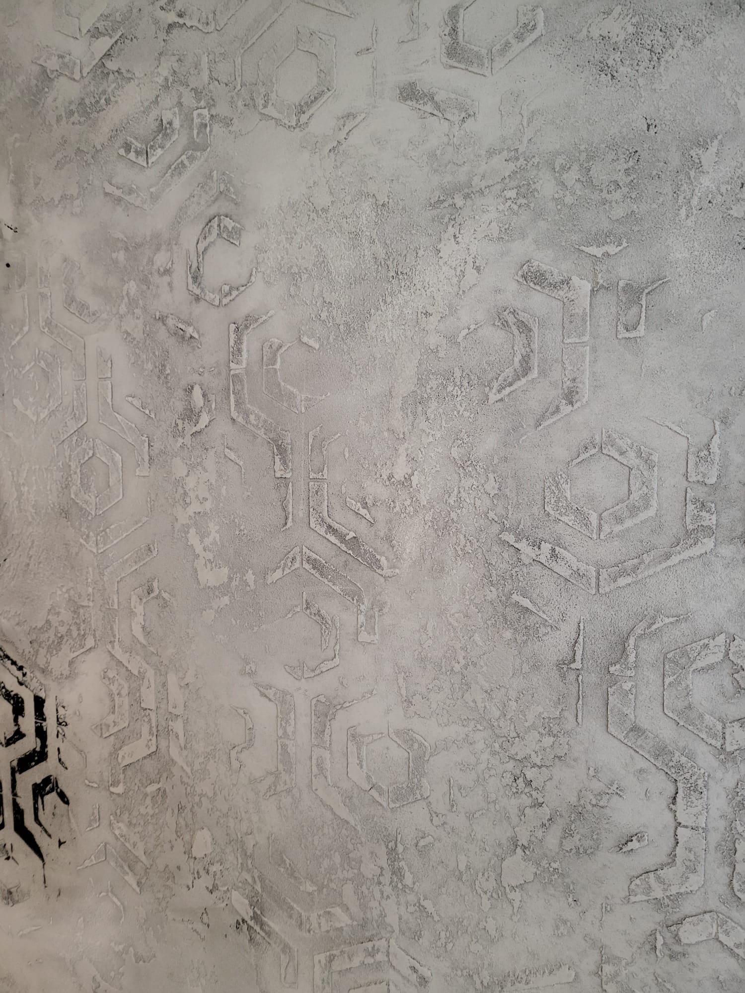 Helle mineralische Wandgestaltung mit geometrischen Reliefmotiven