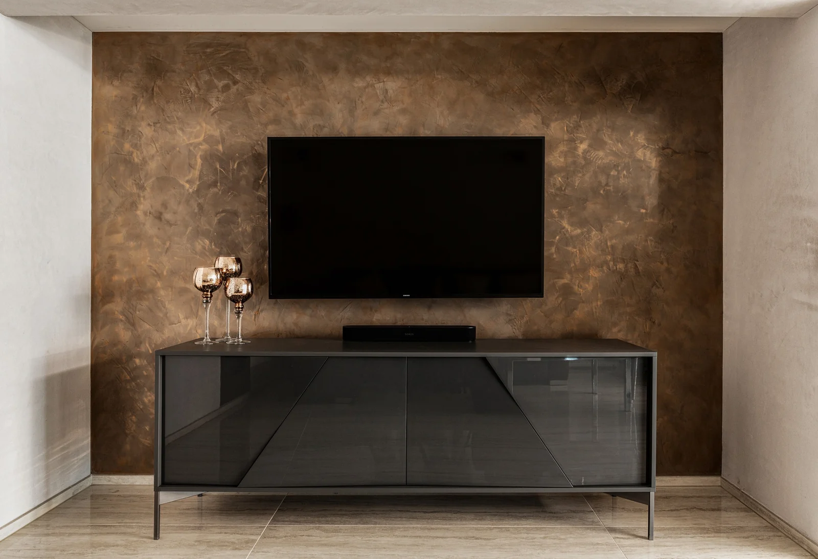 Metallisch schimmernde Wandgestaltung hinter einem Fernseher