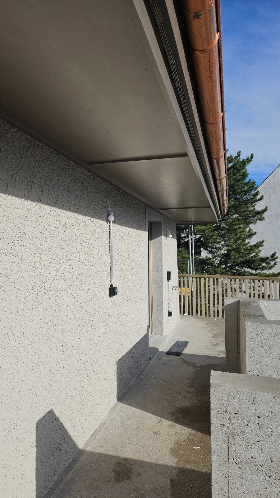Detail einer strukturierten Putzfassade mit Dachuntersicht