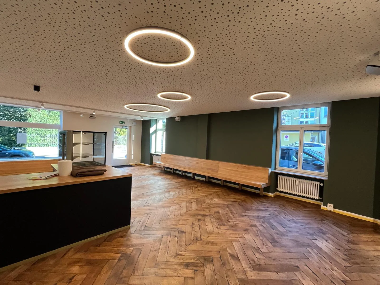 Sanierter Saal mit farbigen Wänden und gelochter Decke