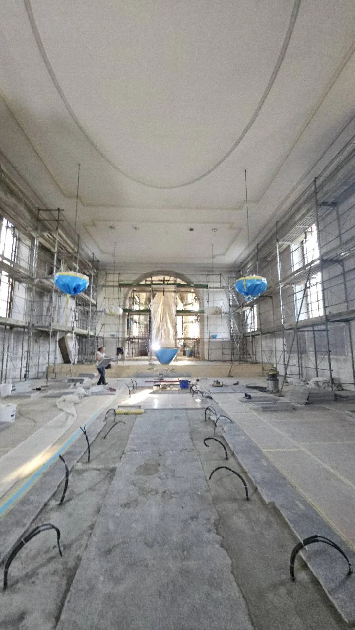 Arbeiten an den Deckenprofilen in einer eingerĂĽsteten Kirche
