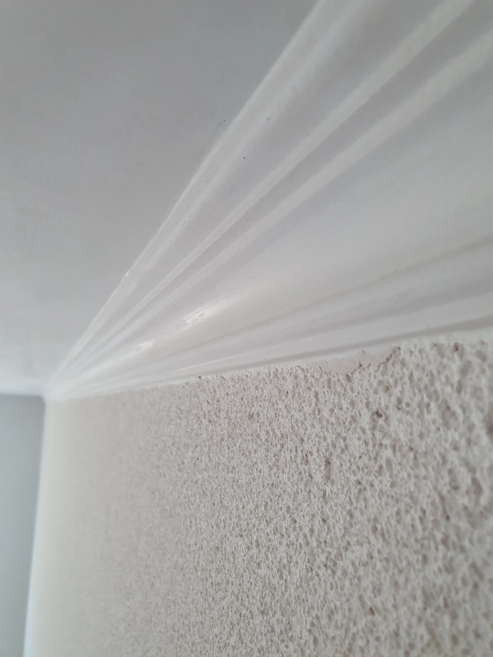 Stuckprofil am Ăśbergang von der verputzten Wand zur Decke