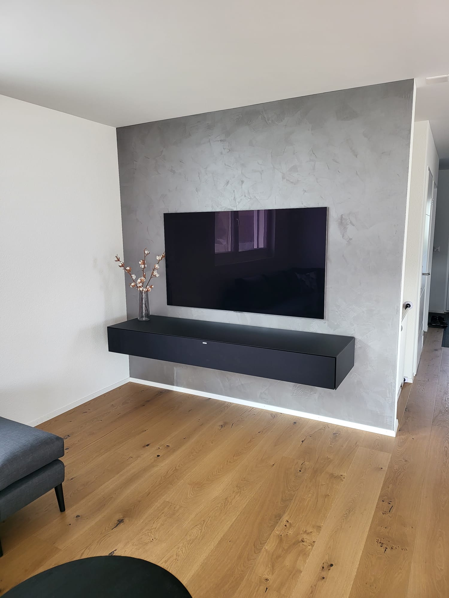 Silbrig gestaltete TV-Wand mit sichtbarer Spachtelstruktur