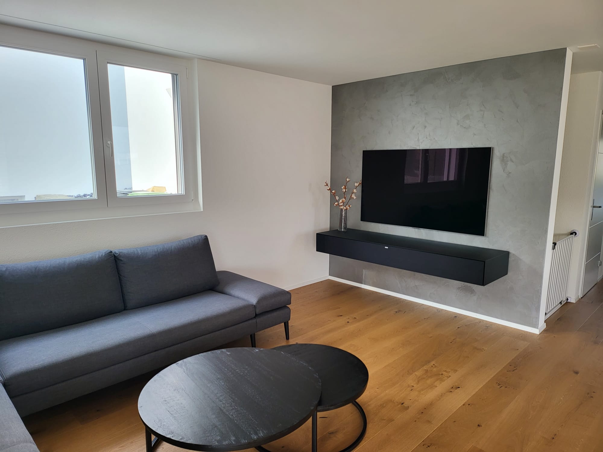 Wohnraum mit silbrig schimmernder TV-Wand
